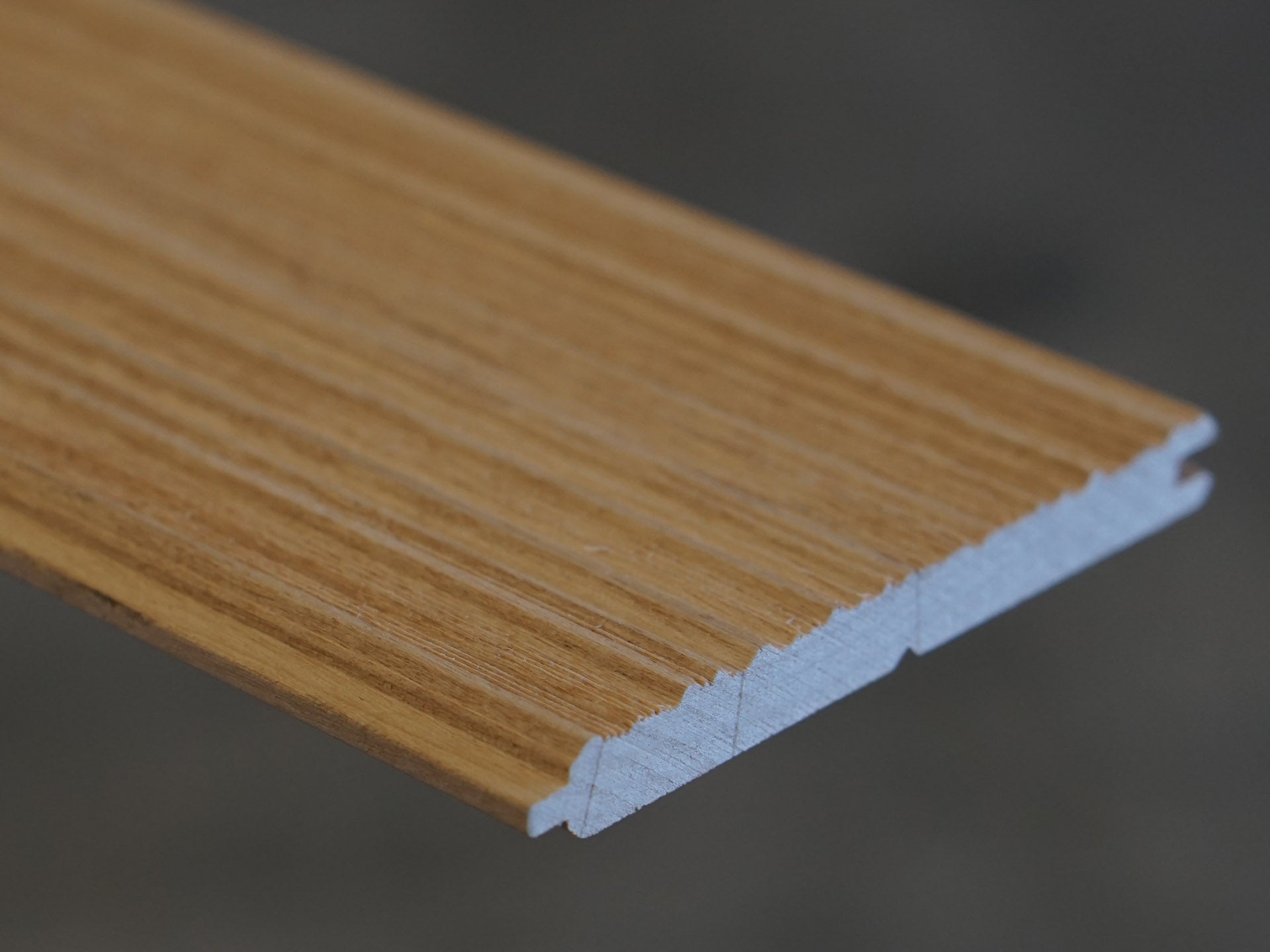 Close up of Weldtex tongue & groove alder hardwood  plank consisting of a combed, striated, brushed wood appearance common in mid-century modern homes and design