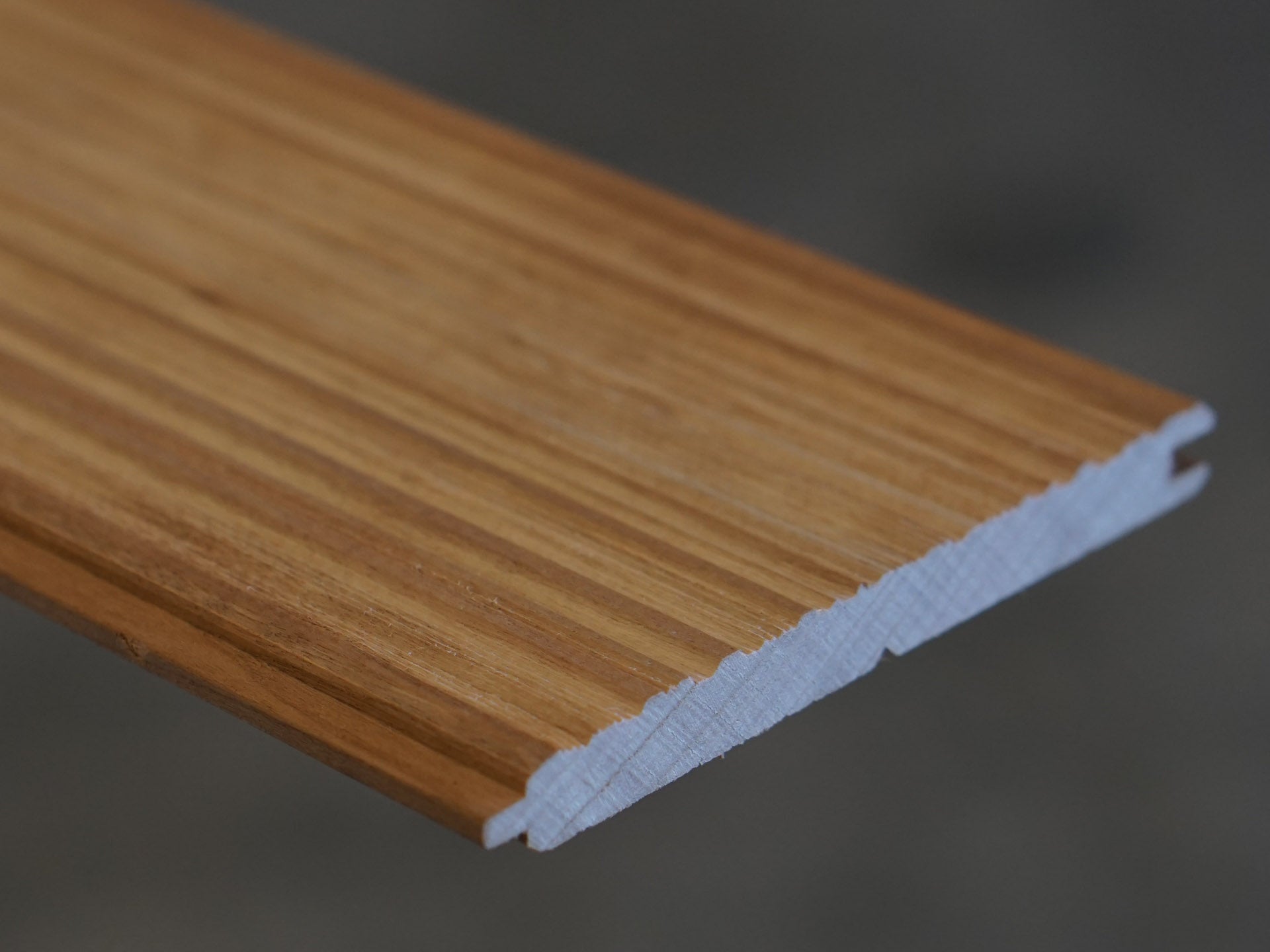 Close up of Weldtex tongue & groove cherry hardwood plank consisting of a combed, striated, brushed wood appearance common in mid-century modern homes and design