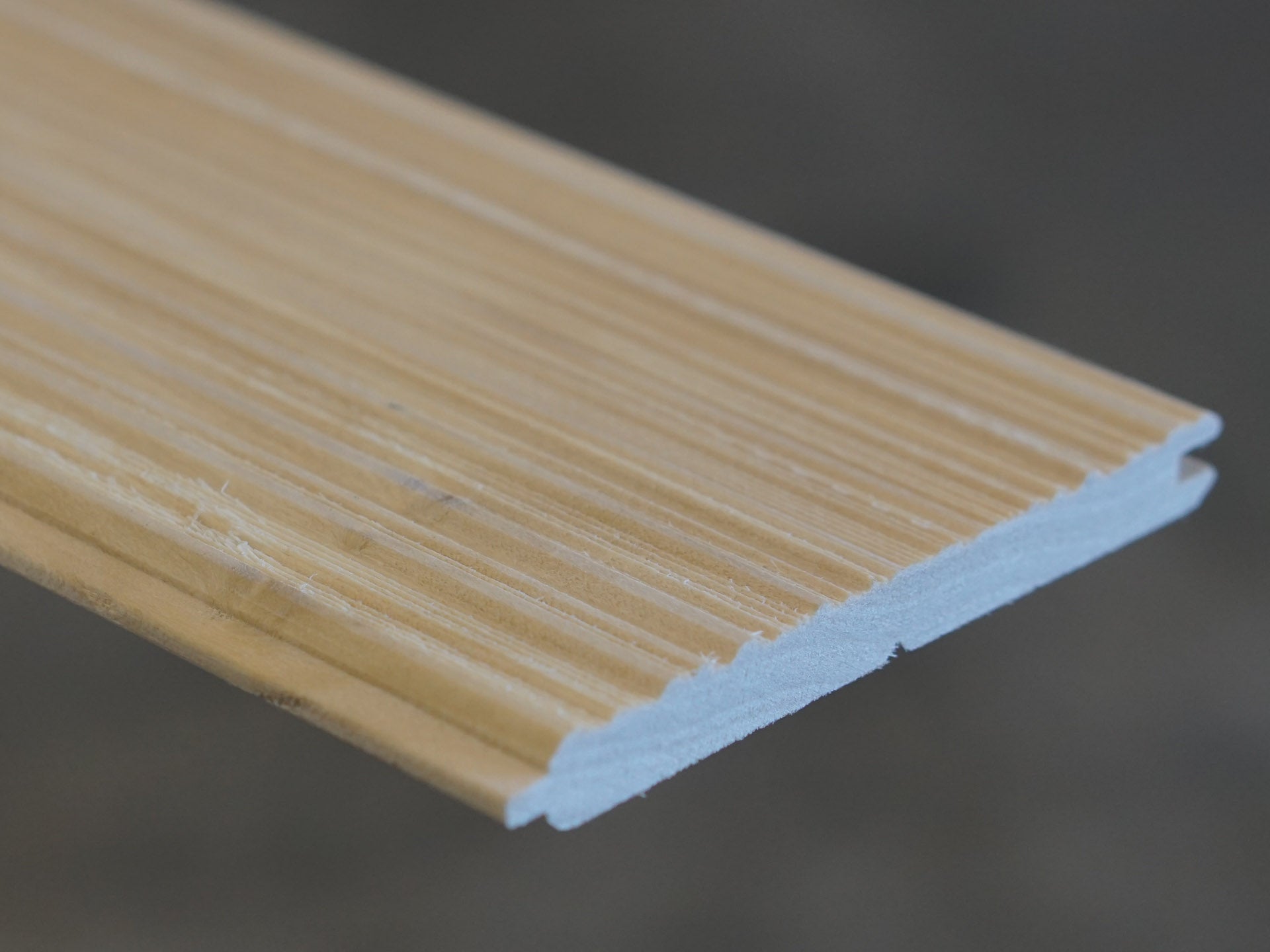 Close up of Weldtex tongue & groove poplar hardwood plank consisting of a combed, striated, brushed wood appearance common in mid-century modern homes and design