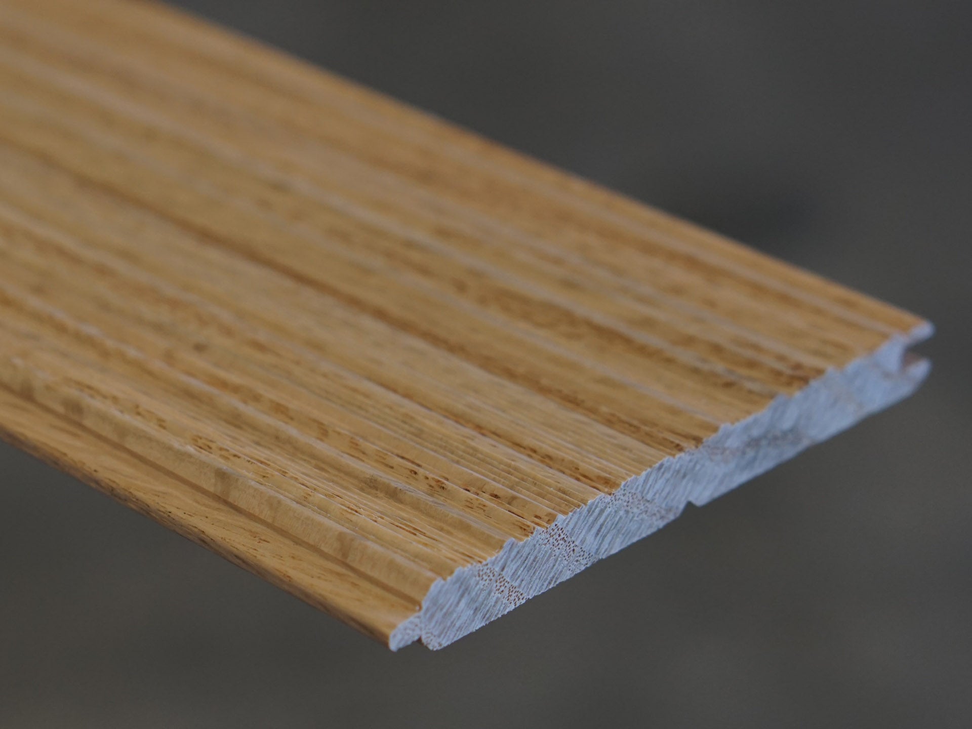 Close up of Weldtex tongue & groove red oak hardwood plank consisting of a combed, striated, brushed wood appearance common in mid-century modern homes and design